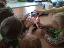 dzieci dotykające kuli elektrostatycznej