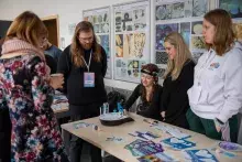 studenci przy stoisku na korytarzu