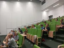 uczestniczy wykładu na auli